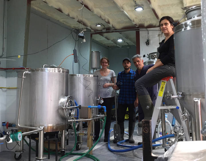 group of workawayers and host in an artisan brewery smiling at camera