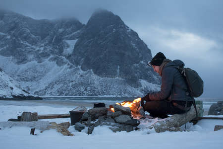 lighting a fire before camping in the snow