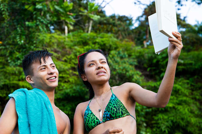 two travellers read book in tropical beach