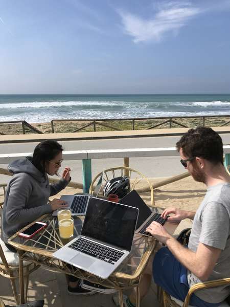 digital nomad friend group working ourdoors ocean view