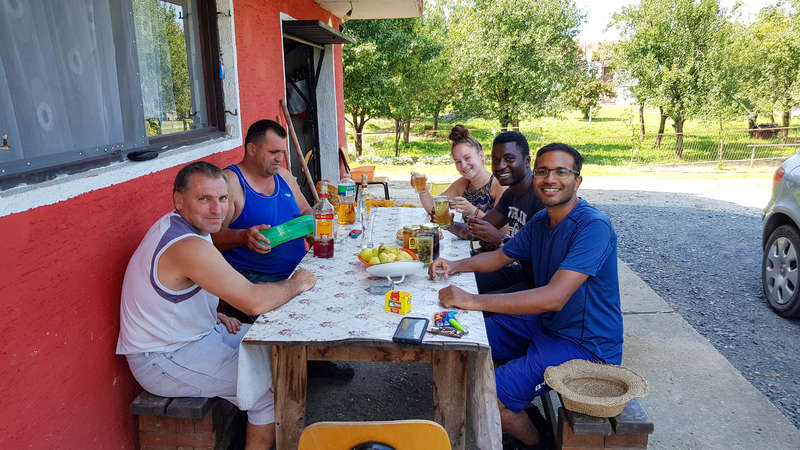 travel and workaway group sit around porch smiling drinks