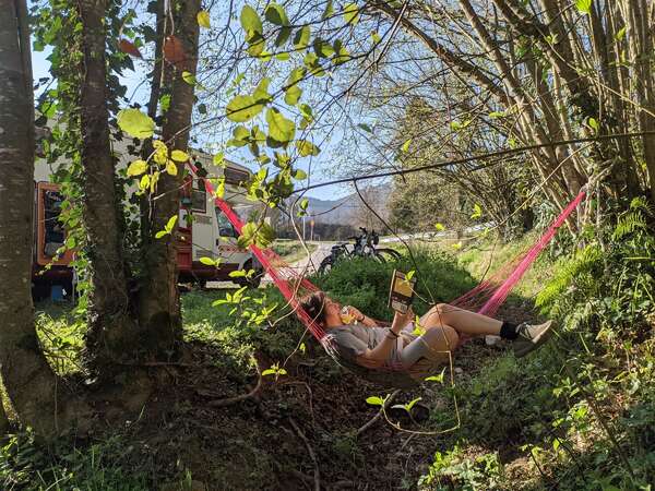 van life slow travel workaway reading break on hammock in nature forest trees