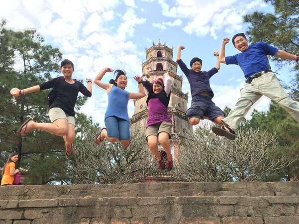 su family with children jumping up with pagoda background travel