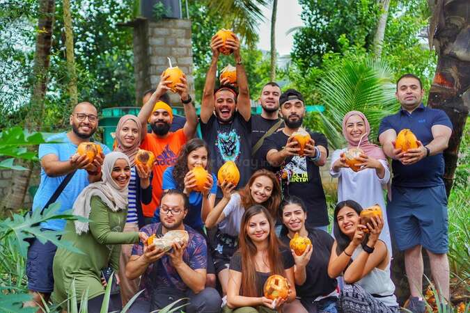 coconut picking group photo with locals and travellers outdoors