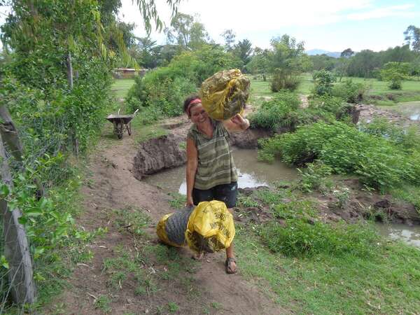 carrying heavy sacks for sustainable project with happiness