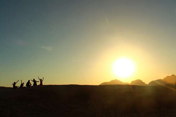 A group of volunteers enjoying the sunset in the deserts of Jordan