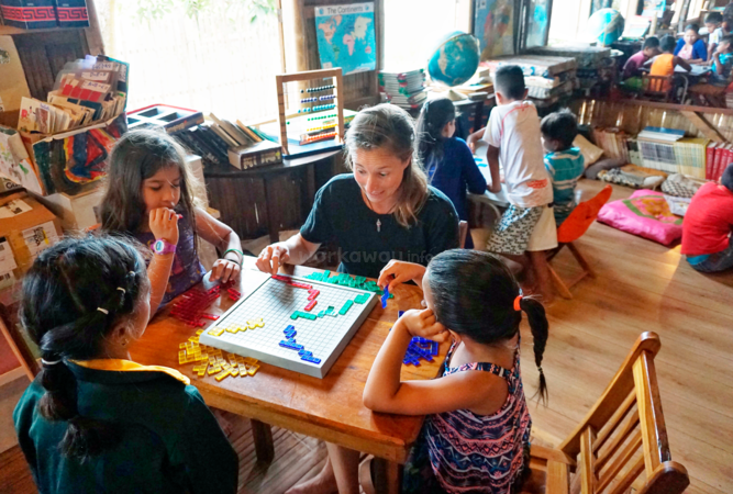 workawayer volunteer and local children playing scrabble in community library