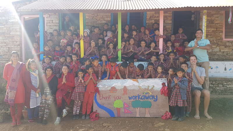 group photo of village class students with hands in prayer and 'thank you workaway' sign