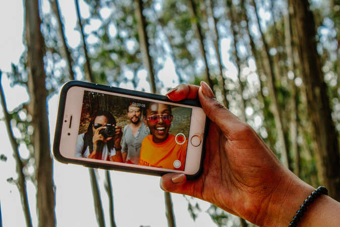 three friends recording a selfie video on their iphone