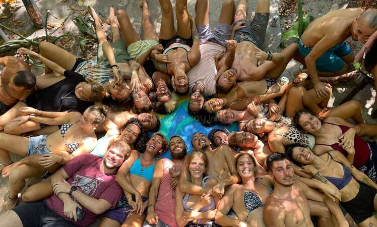 group travel photo of beach partygoers all lying on the floor laughing