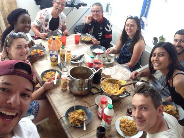 workawayers and hosts of different ages and nationalities sharing a meal around a table