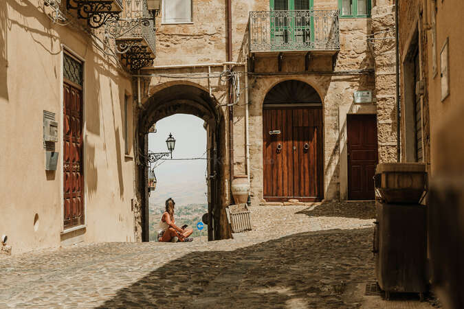 solo woman travelling and looking at view through building door