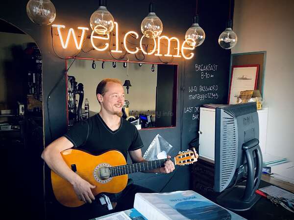 playing guitar at hostel reception 