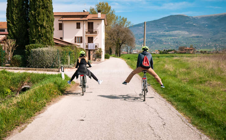 travellers cycling through mountainous villgae