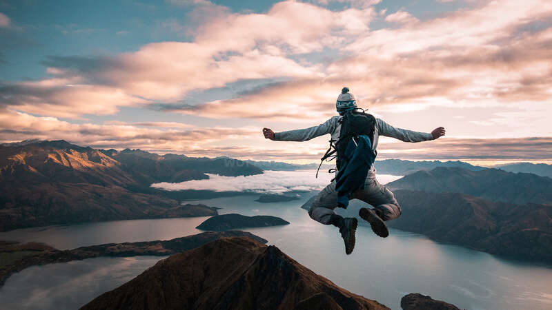 solo hiker jumping in new zealand