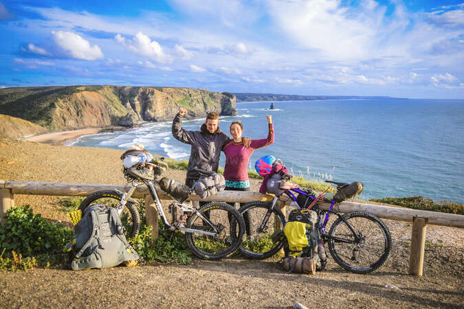 couple bike packing along coast line