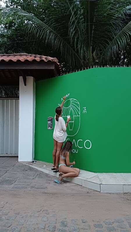 Workawayers Carmen and Victoria painting surf hostel sign