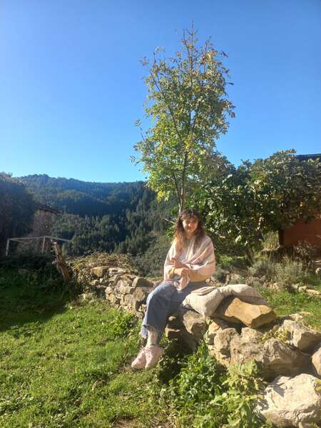 girl-sitting-stone-wall-garden